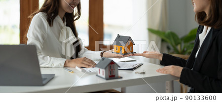 experienced real estate agent showing house model to client and ready to sign contract 90133600