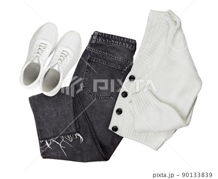 Set of white knitted cardigan, black jeans and leather sneackers isolated on white. Flat lay. Trendy casual outfit Set of white knitted cardigan, black jeans and leather sneackers isolated on white. Flat lay. Trendy casual outfit 90133839