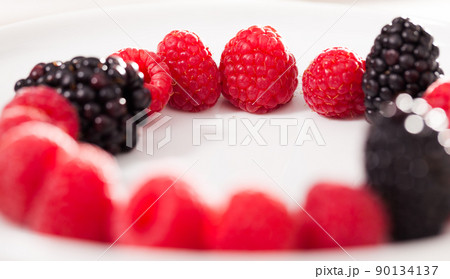 raspberries and blackberries laid out on a white plate in circle raspberries and blackberries laid out on a white plate in circle 90134137