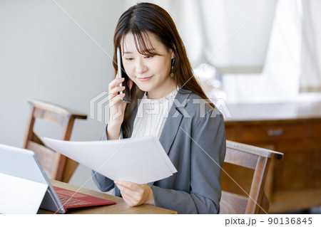 資料を見ながら問い合わせをする女性 90136845