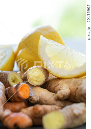 Roots of ginger and turmeric with lemon on plate Roots of ginger and turmeric with lemon on plate 90136907