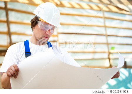 builder manager looking at the construction plan 90138403