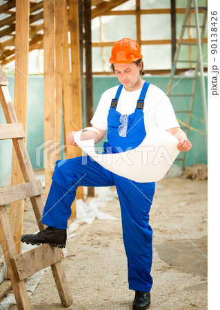 builder looking at the construction plan 90138426