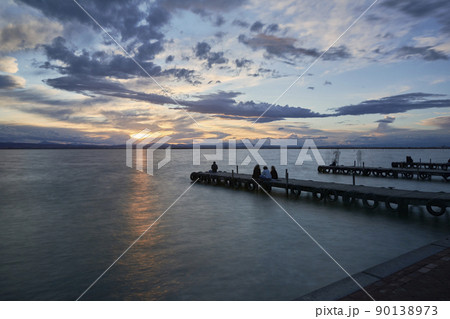 Jetty on a lake a stormy day, sunset 90138973