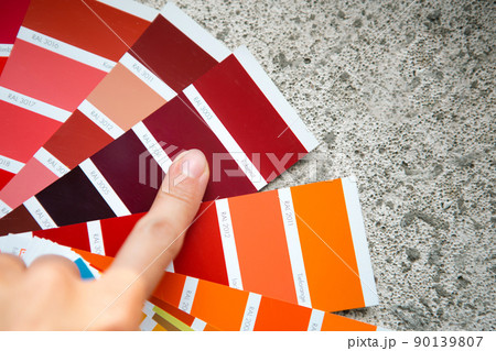 Selection of the paint color for decorative home repairs to the palette with layouts. A fan of shades in your hand inside the home. Repair and construction, paint and varnish coating Selection of the paint color for decorative home repairs to the palette with layouts. A fan of shades in your hand inside the home. Repair and construction, paint and varnish coating 90139807