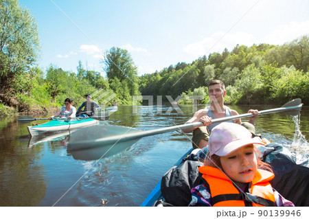 Family kayak trip. Father and daughter, and elderly couple senior and seniora rowing boat on the river, a water hike, a summer adventure. Eco-friendly and extreme tourism, active and healthy lifestyle 90139946