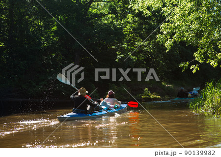 Family kayak trip. Man and woman and elderly couple senior and seniora rowing boat on the river, a water hike, a summer adventure. Eco-friendly and extreme tourism, active and healthy lifestyle 90139982