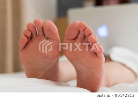 ベッドでパソコンを使用している女性 足裏 ベッドでパソコンを使用している女性 足裏 90142813