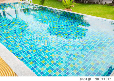 Macro from Swimming pool with clear blue water in a garden area, surrounded by plants Macro from Swimming pool with clear blue water in a garden area, surrounded by plants 90144147