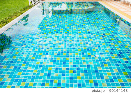 Macro from Swimming pool with clear blue water in a garden area, surrounded by plants Macro from Swimming pool with clear blue water in a garden area, surrounded by plants 90144148