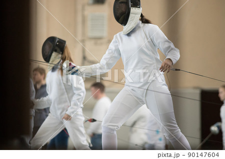 Young people fencers standing in the hall on a fencing tournament and getting ready for the fight 90147604