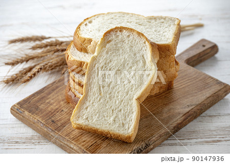 カッティングボードの上のパンと麦穂 90147936