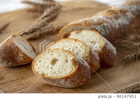 カッティングボードの上のパンと麦穂 90147951