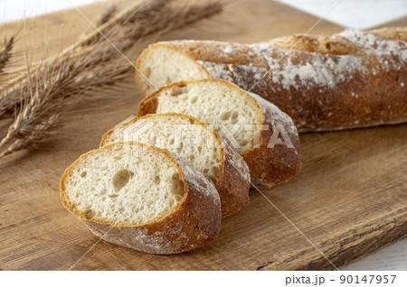 カッティングボードの上のパンと麦穂 90147957
