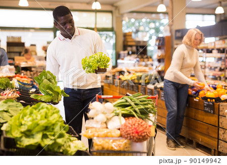 Man buying vegetables in supermarket 90149942