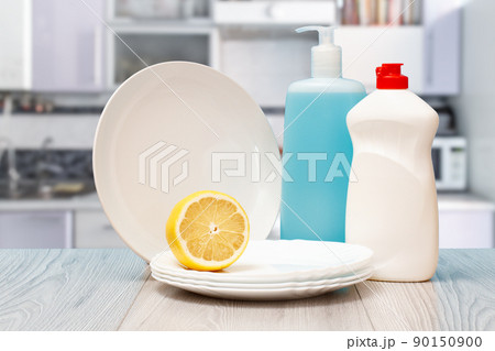 Bottles of dishwashing liquid, plates and lemon. Bottles of dishwashing liquid, plates and lemon. 90150900