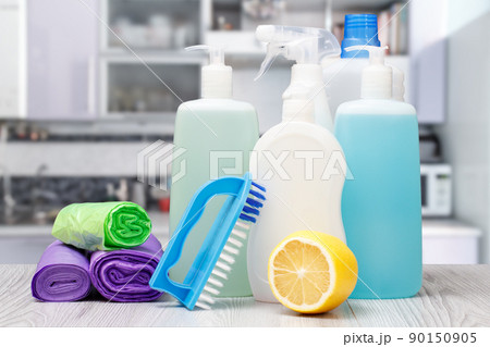Bottles of dishwashing liquid, brush and lemon. 90150905