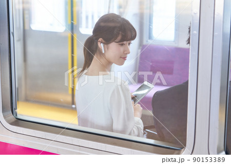 電車内でスマホを見る若い女性　撮影協力「京王電鉄株式会社」 90153389