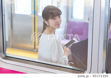 電車内でスマホを見る若い女性　撮影協力「京王電鉄株式会社」 90153390