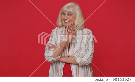 Senior woman smiling friendly at camera and waving hands gesturing hello or goodbye, welcoming 90153927