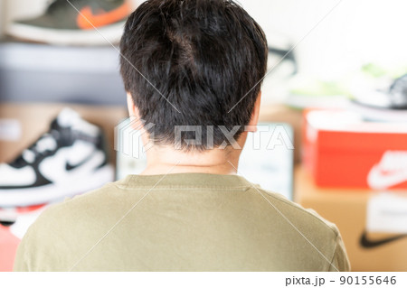 自宅でスニーカー投資をする男性 自宅でスニーカー投資をする男性 90155646
