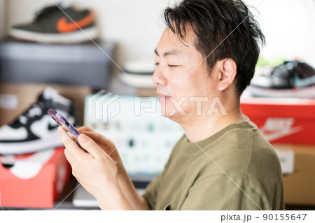 ブランドスニーカーをアプリで転売目的で購入する男性 90155647