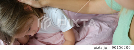 Little girl is sad on the bed, next to mom Little girl is sad on the bed, next to mom 90156206