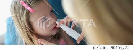 Mom sprays the baby's nose with spray Mom sprays the baby's nose with spray 90156225