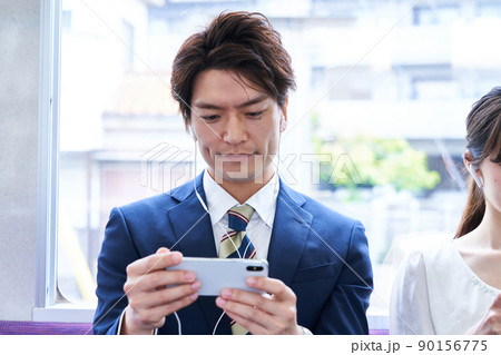 電車内でスマホを見るスーツ姿の男性 撮影協力「京王電鉄株式会社」 電車内でスマホを見るスーツ姿の男性 撮影協力「京王電鉄株式会社」 90156775
