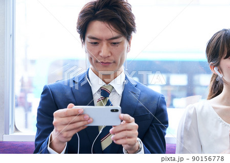 電車内でスマホを見るスーツ姿の男性 撮影協力「京王電鉄株式会社」 電車内でスマホを見るスーツ姿の男性 撮影協力「京王電鉄株式会社」 90156778