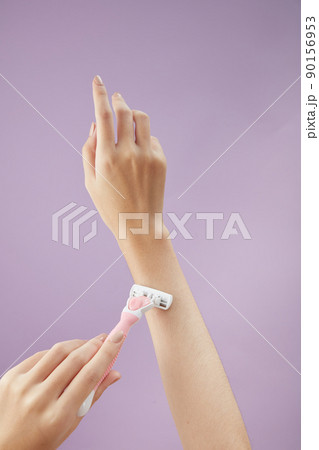 Top view of holding cosmetic roller on hand in purple background for cosmetic advertising Top view of holding cosmetic roller on hand in purple background for cosmetic advertising 90156953