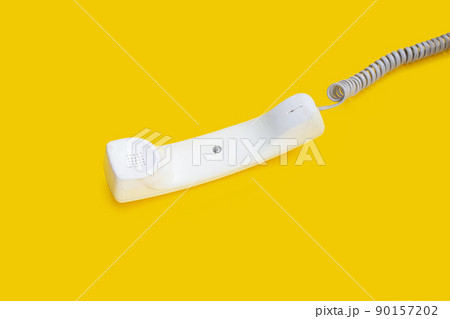 Handset of landline phone on yellow background. 90157202