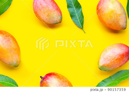 Tropical fruit, Frame made of mango on yellow background. Top view 90157359