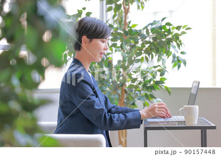 クリエイティブオフィスでデスクワークするビジネスウーマンの横顔1 90157448