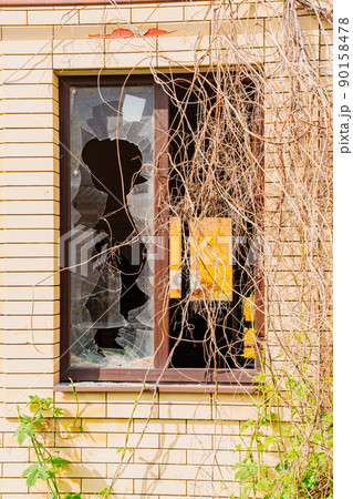 broken glass in the windows of abandoned houses. broken glass in the windows of abandoned houses. 90158478