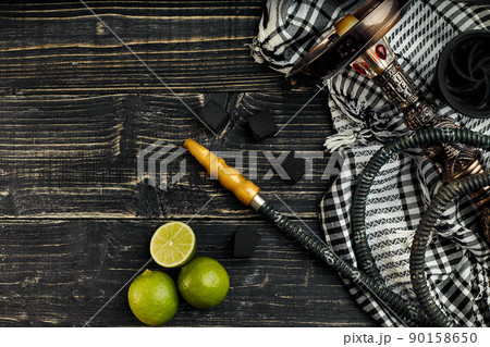 Arabic hookah with a tobacco flavor of a mixture of lime. Top view of a dark wooden background 90158650