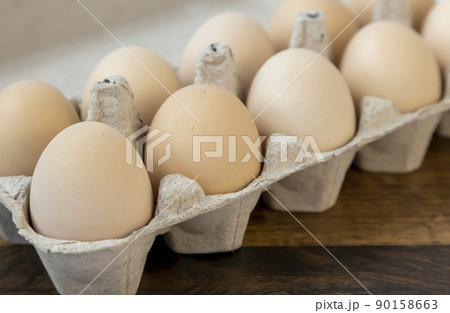 Organic chicken eggs, in a cardboard tray, close up. 90158663