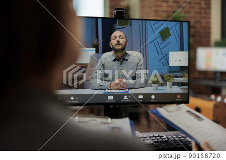 Businesswomen reading cv discussing application plan with remote candidate during online videocall meeting conferene in startup company office. Hiring teleconference call on computer screen Businesswomen reading cv discussing application plan with remote candidate during online videocall meeting conferene in startup company office. Hiring teleconference call on computer screen 90158720