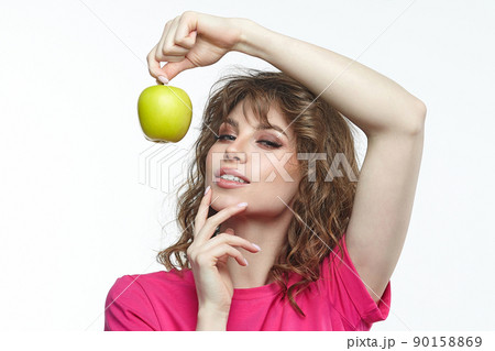 attractive girl seductively holds a ripe green apple in her hands. 90158869