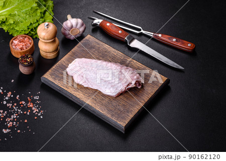 Fresh raw turkey wing with spices and herbs on a wooden cutting board Fresh raw turkey wing with spices and herbs on a wooden cutting board 90162120
