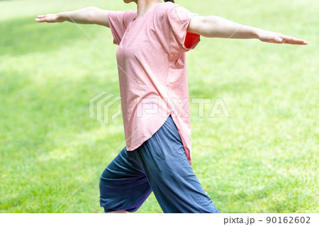 新緑の芝生でヨガをする女性【パーツカット】 90162602