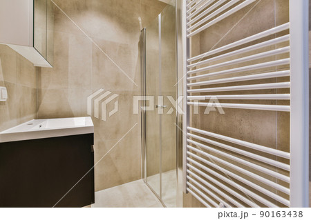 Glass partition between shower cabin and sink under the mirror in modern restroom at home Glass partition between shower cabin and sink under the mirror in modern restroom at home 90163438