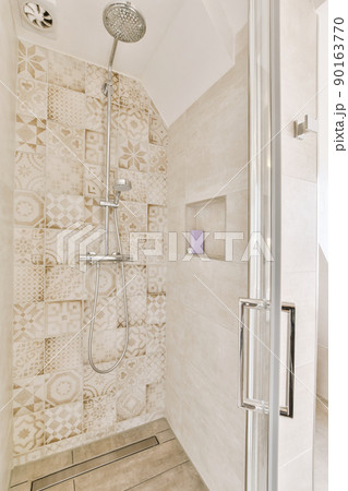 Bathroom in gray tones with a glass shower cabin in a modern house 90163770