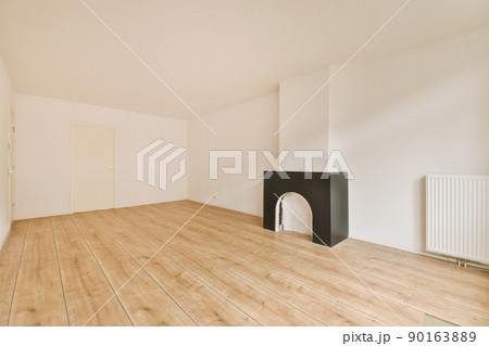 Interior of spacious light room with fireplace and elegant chandelier against balcony door and windows Interior of spacious light room with fireplace and elegant chandelier against balcony door and windows 90163889