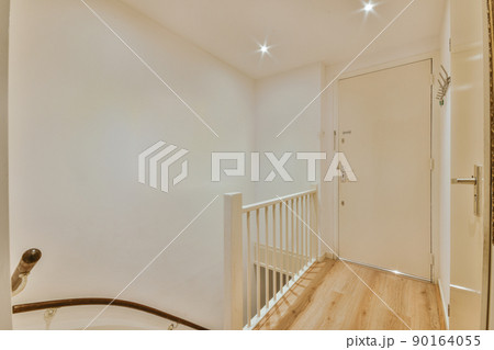 Spacious bright corridor with a staircase leading to a cozy apartment of a modern house Spacious bright corridor with a staircase leading to a cozy apartment of a modern house 90164055