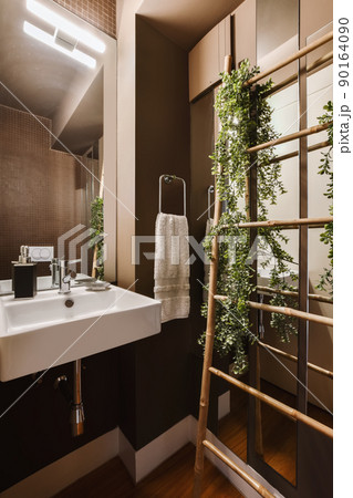 A lovely dark bathroom with a square sink and a flower 90164090