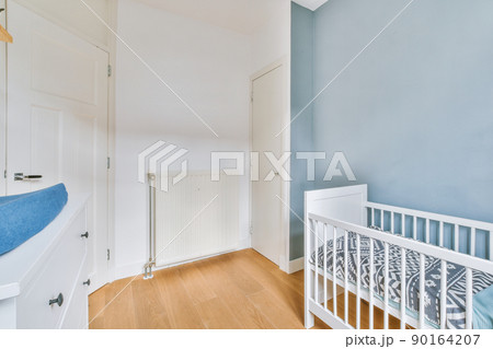 A spacious children's room with a bed with fences in bright colors in a cozy modern house 90164207