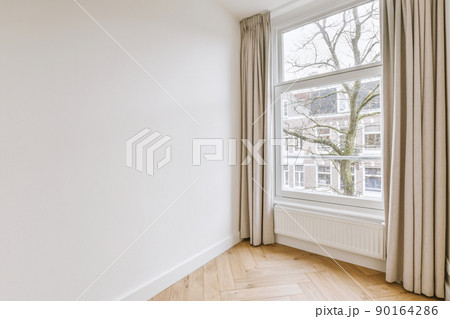 Plastic window and radiator on white wall in empty light room at home 90164286