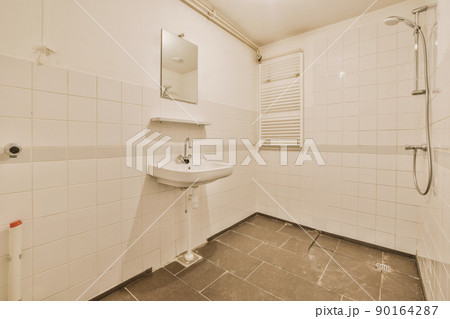 Sinks with mirrors and shower box with glass door in modern bathroom with white tiled walls 90164287
