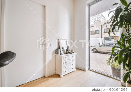 A small bright room in a cozy modern house with a panoramic window and a houseplant 90164295
